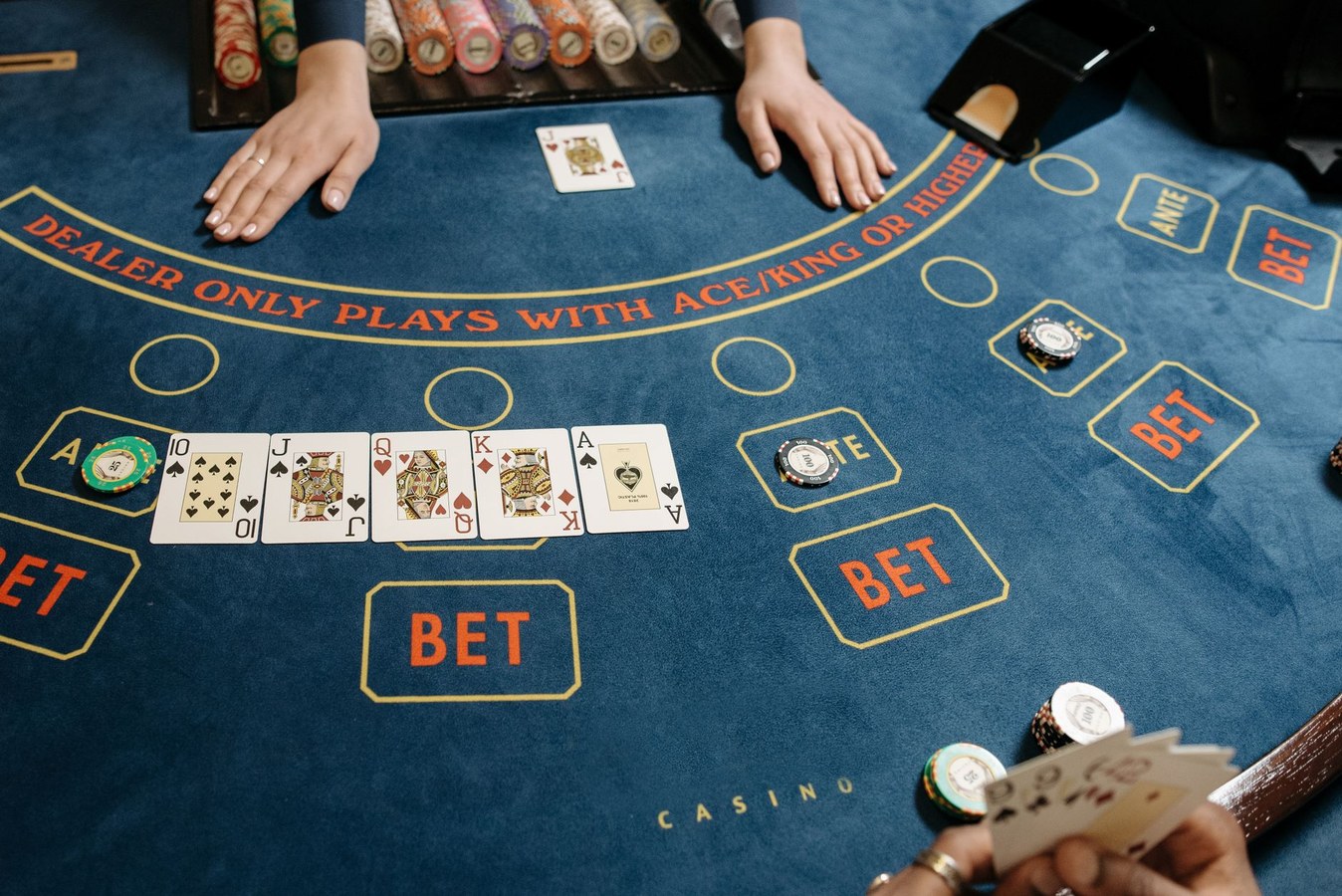Dealer hands managing chips and cards in a betmatch game